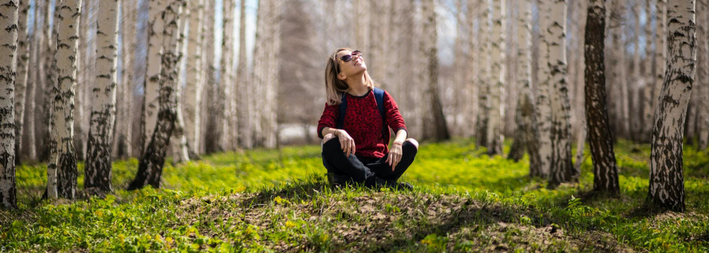 Frau sitzt im Wald