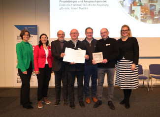 Susanne Sadremoghaddam (Jurorin der HWK Schwaben), Vroni Walter (Jurorin der Wirtschaftsjunioren), Reiner Erben (Referent für Nachhaltigkeit, Umwelt, Klima und Gesundheit), Bernd Radtke (Geschäftsführer DHB), Pfarrer Fritz Graßmann (Theologischer Vorstand DWA), Ralf Hailand (stellvertretender Geschäftsführer DHB) und Oberbürgermeisterin Eva Weber.